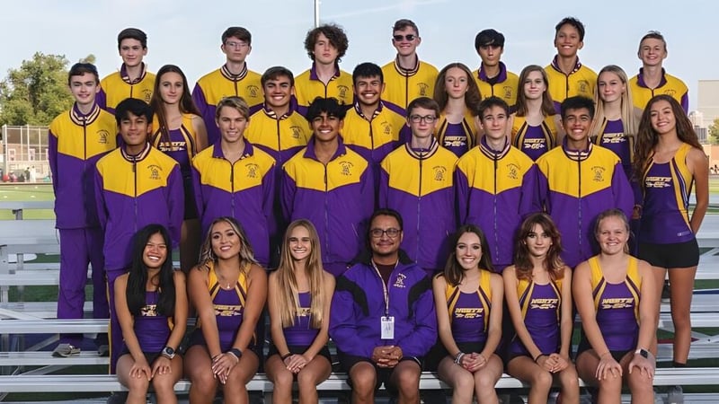 Eine Gruppe junger Athleten in gelb-lila Uniformen posiert auf dem Sportfeld des Denver Public School District mit einem Stadion im Hintergrund.