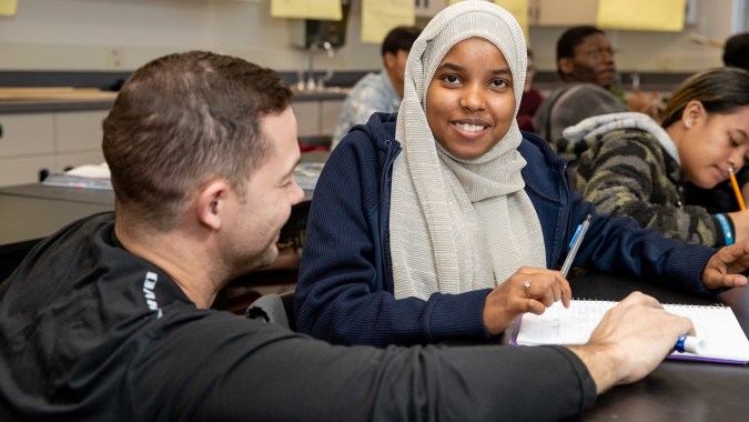 Zwei Personen unterhalten sich in einem Klassenraum des Denver Public School District.