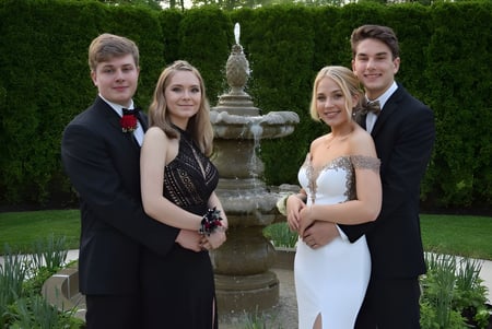 Vier Personen posieren vor einem Brunnen auf dem Gelände der Devonport High School.