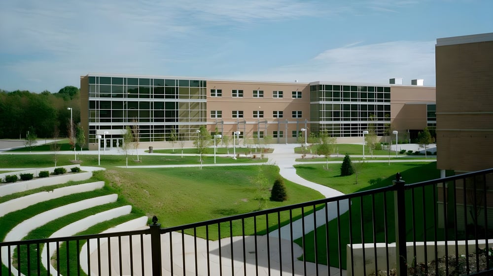 Das moderne mehrstöckige Gebäude der Dexter High School mit Glaswänden und einem begrünten Innenhof im Vordergrund.