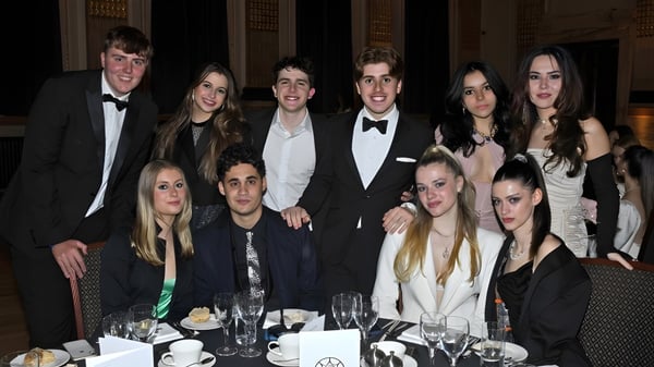 Eine Gruppe von Personen sitzt bei einem formellen Abendessen auf dem Campus des DLD College London.