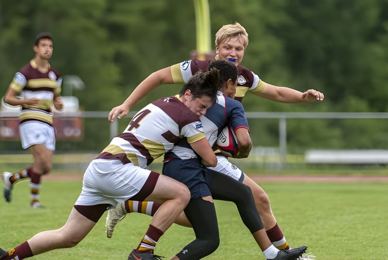 Zwei Rugbyspieler der Dollar Academy führen auf dem Spielfeld einen Tackling-Versuch aus.