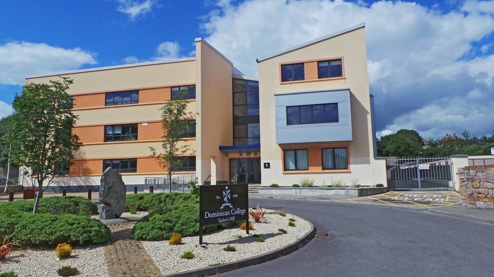Das mehrstöckige Gebäude des Dominican College in Galway mit angelegtem Vorgarten und gepflasterter Einfahrt.