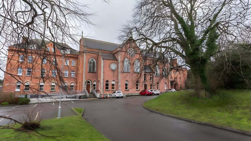 Das große gemauerte Gebäude mit Uhrturm auf dem Gelände des Dominican College in Wicklow ist von kahlen Bäumen umgeben.