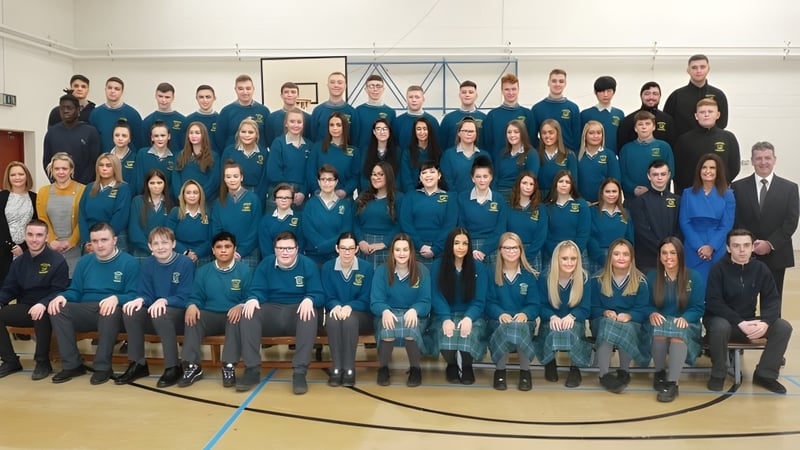 Eine große Gruppe Schüler der Donahies Community School sitzt in blauen und schwarzen Schuluniformen bei einer Versammlung.