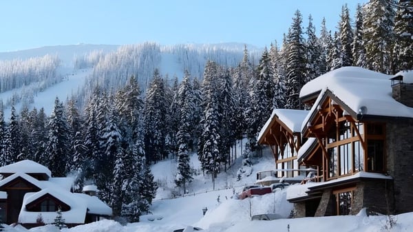 Eine verschneite Berglandschaft mit einer Holzhütte zwischen Kiefern auf dem Gelände der Donald A. Wilson School.