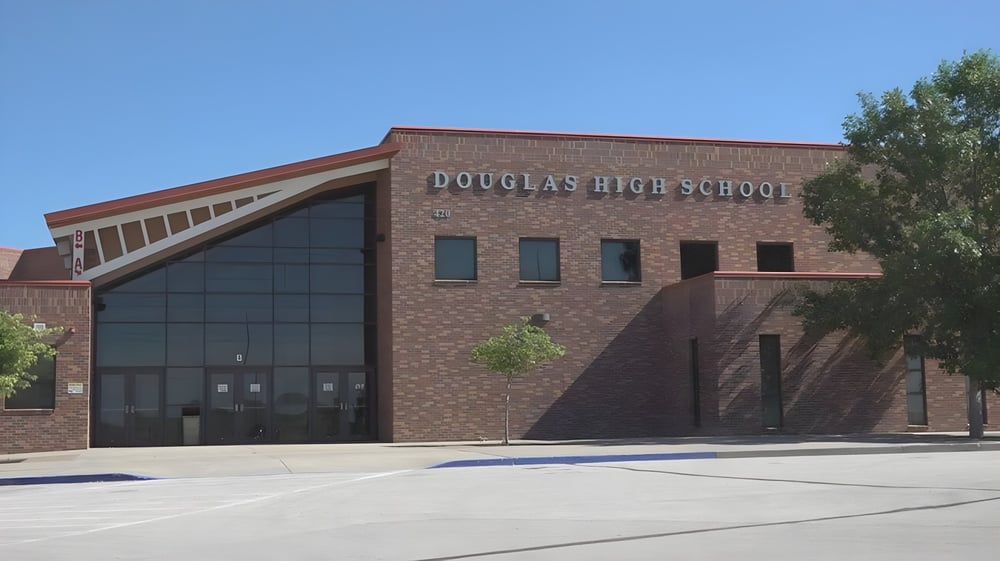 Das Backsteingebäude der Douglas Community School ist umgeben von Bäumen und einem gepflasterten Vorplatz.