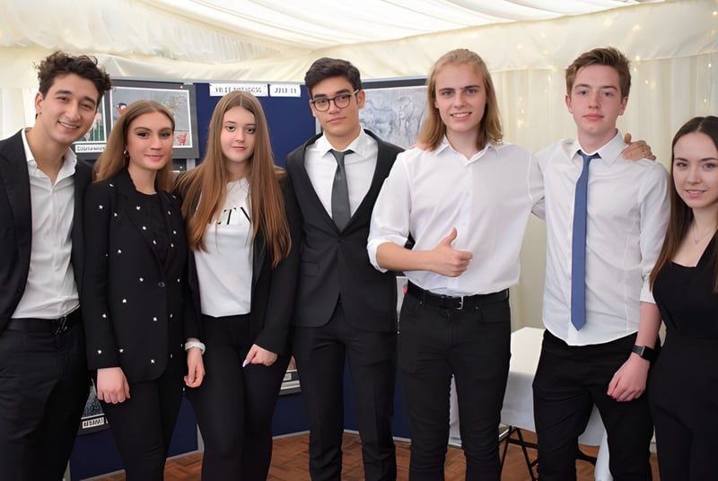 Eine Gruppe von Schülerinnen und Schülern des D'Overbroeck's College posiert in formeller Kleidung vor einem weißen Zelt.