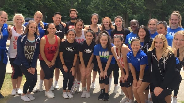 Eine Gruppe von Schülerinnen und Schülern der Dr. Charles Best Secondary School steht gemeinsam draußen in einem parkähnlichen Bereich mit Bäumen im Hintergrund.