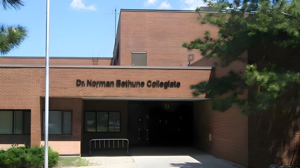 Das Backsteingebäude des Dr. Norman Bethune Collegiate Institute mit umliegenden Bäumen und klarem Himmel.