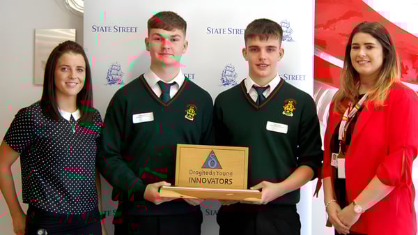Vier Schülerinnen und Schüler der Drogheda Grammar School halten gemeinsam die Trophäe Designated Innovators in der Schule.