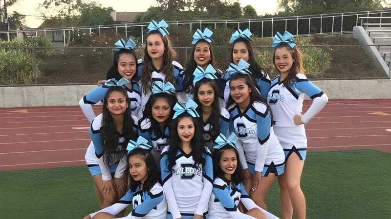 Eine Gruppe junger Frauen in Cheerleading-Uniformen posiert gemeinsam auf dem Sportfeld des Duarte Unified School District.