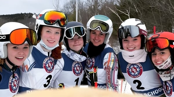 Eine Gruppe von Schülerinnen und Schülern der Dublin School posiert in Skiausrüstung zusammen in einer verschneiten Landschaft.