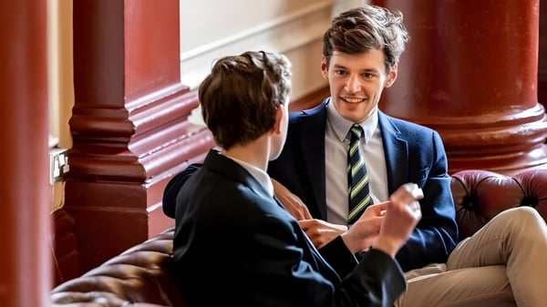 Zwei Personen führen ein Gespräch im formellen Ambiente auf dem Campus des Dulwich College.