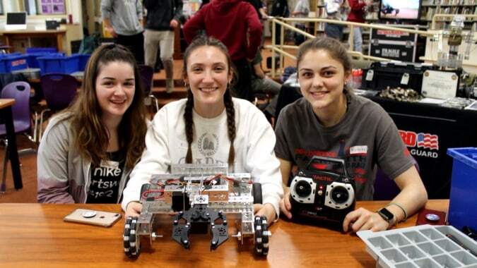 Drei Schülerinnen der Dundalk Grammar School sitzen im Robotic Workshop und präsentieren ein Robotergerät.