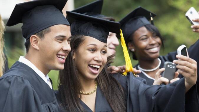 Eine Gruppe von Absolventinnen und Absolventen des Dungarvan College macht gemeinsam ein Selfie vor grünem Hintergrund.