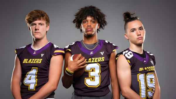 Drei Schüler der Durango High School tragen Fußballtrikots der Blazers vor grauem Hintergrund.
