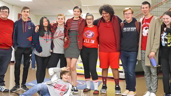 Eine Gruppe von Schülerinnen und Schülern steht zusammen im Gemeinschaftsbereich der D.W. Poppy Secondary School.