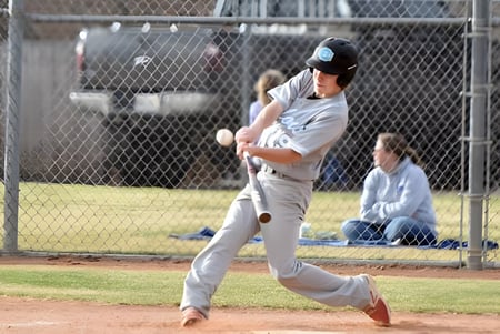 Ein Baseballspieler der Eagle Butte High School steht auf dem Pitchers Mound vor einem Zaun mit Zuschauern im Hintergrund.