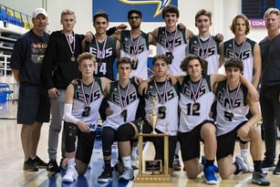 Schüler der Earl Marriott Secondary School posieren in Sportkleidung mit einem gewonnenen Pokal in der Turnhalle.