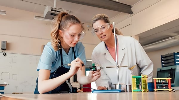 Zwei Frauen in medizinischer Kleidung arbeiten gemeinsam im Labor der Earl of March Secondary School mit wissenschaftlicher Ausrüstung.