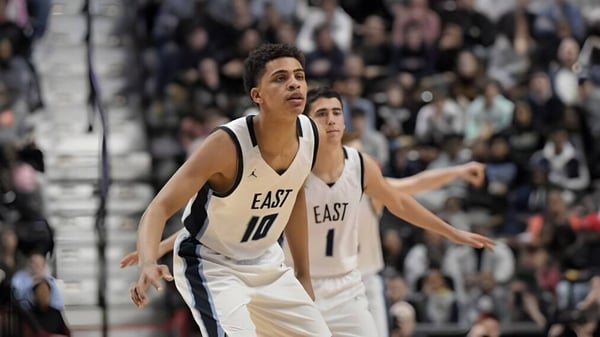 Ein Basketballspieler der East Catholic High School steht auf dem Spielfeld vor einer großen Zuschauermenge.