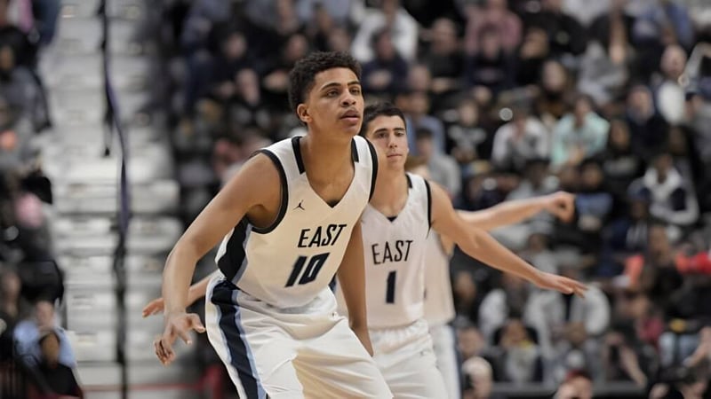 Ein Basketballspieler der East Catholic High School steht auf dem Spielfeld vor einer großen Zuschauermenge.