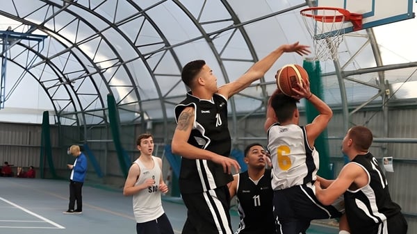 Schüler spielen Basketball in der Sporthalle des East Sussex College Eastbourne.