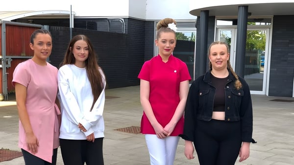 Vier Schülerinnen stehen gemeinsam vor einem Gebäude auf dem Campus des East Sussex College Lewes.