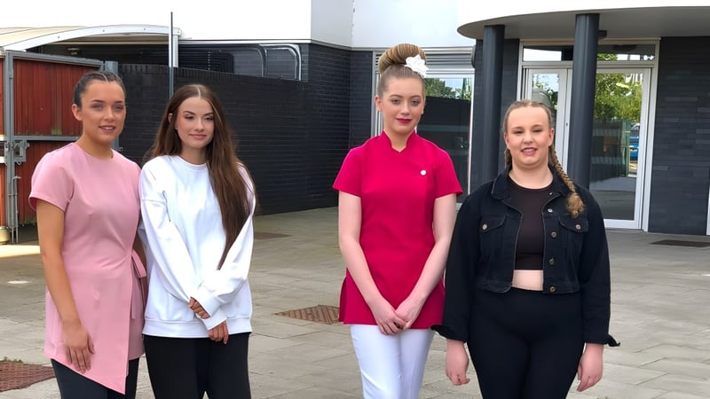 Vier Schülerinnen stehen gemeinsam vor einem Gebäude auf dem Campus des East Sussex College Lewes.