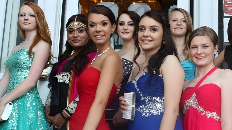 Eine Gruppe Schülerinnen der Eastbourne Academy posiert in bunten Kleidern vor einem festlichen Hintergrund bei einer Veranstaltung.