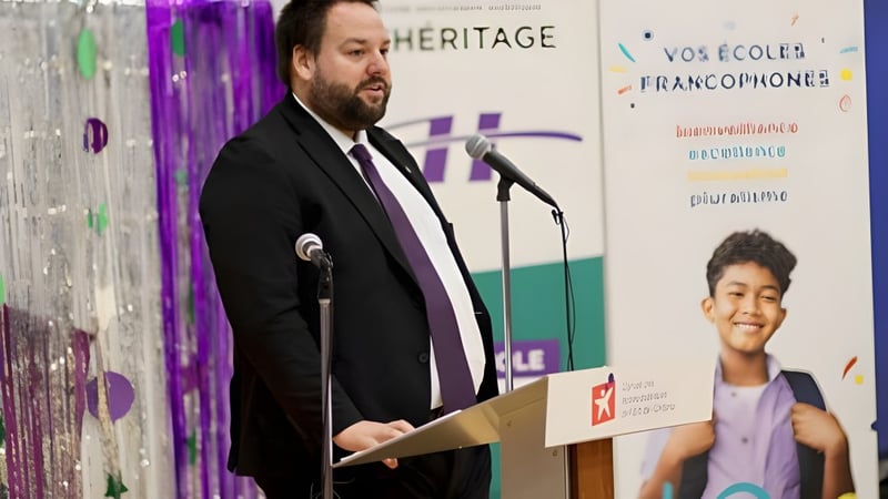 Ein Mann im Anzug hält eine Rede am Rednerpult auf einer Veranstaltung der Eastern Ontario Public Schools.