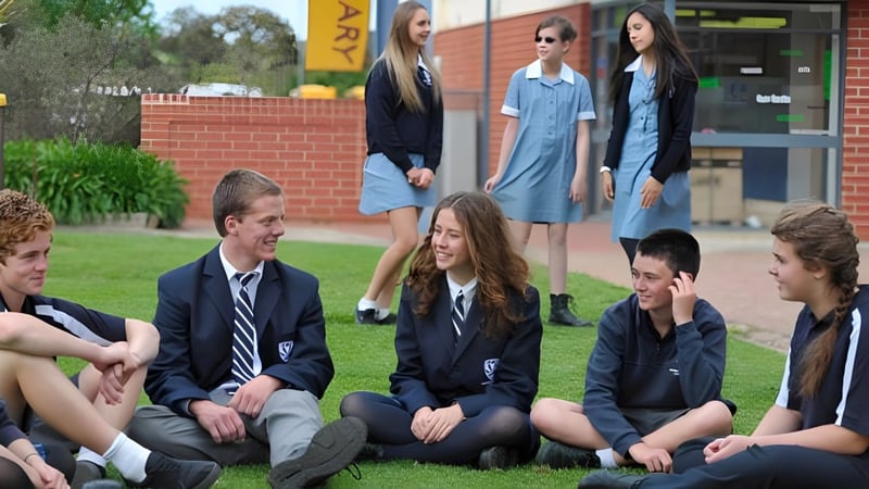 Eine Gruppe von Schülerinnen und Schülern der Eastern Fleurieu R-12 steht im Freien vor einem Backsteingebäude und unterhält sich.