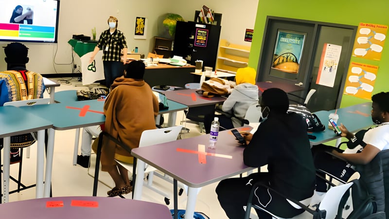 Schüler der École secondaire publique L'Alternative sind in einem farbenfrohen Klassenraum mit Lernmaterialien aktiv.