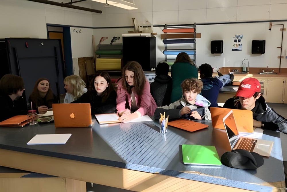 Schülerinnen und Schüler der École Côte du Soleil arbeiten gemeinsam an einem Tisch in einem Klassenraum.