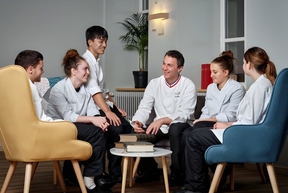 Eine Gruppe von Medizinstudenten der École des Sept Sommets führt eine Besprechung in einem modernen Raum.