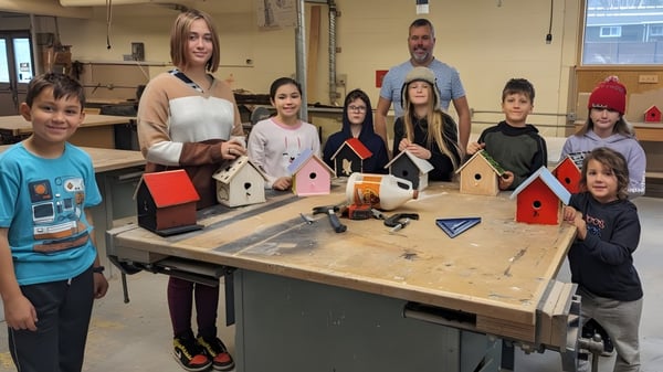 Eine Gruppe von Schülerinnen und Schülern arbeitet in der Werkstatt der École Entre-Lacs an verschiedenen Bastelprojekten wie der Dekoration von Vogelhäusern.