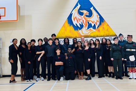 Eine Gruppe Schülerinnen und Schüler steht vor einem großen Wandbild mit einem phönixartigen Wesen an der École Gabrielle-Roy.