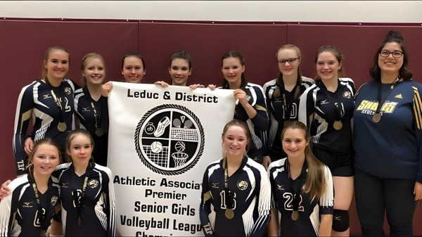 Eine Gruppe von Volleyballspielerinnen der École J.E. Lapointe School posiert gemeinsam mit einem Banner der Leduc & District Athletic Association Premier Senior Girls Volleyball League.