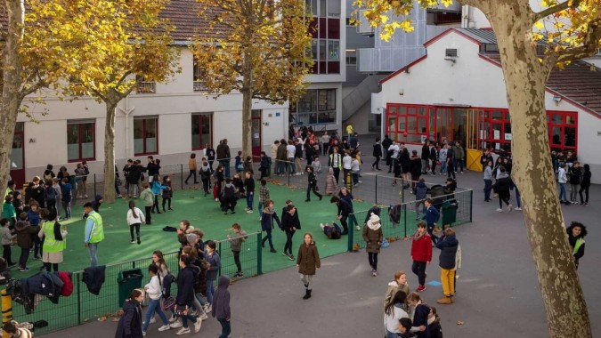 Eine belebte Straßenansicht mit Bäumen und Gebäuden in der Nähe der École Jeannine Manuel.