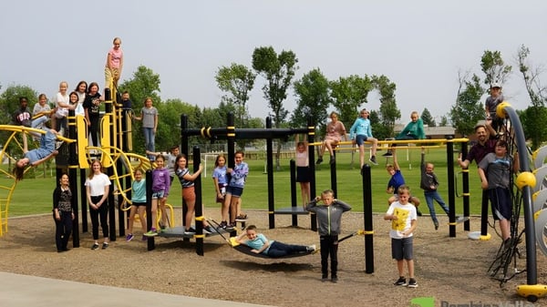 Eine Gruppe von Schülern spielt auf dem bunten Spielplatz auf dem Gelände der École secondaire publique Rivière Rideau.