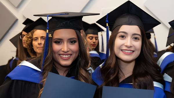 Eine Gruppe junger Frauen in Abschlusskleidung feiert ihre Abschlusszeugnisse auf dem Campus der École Salish Secondary School.