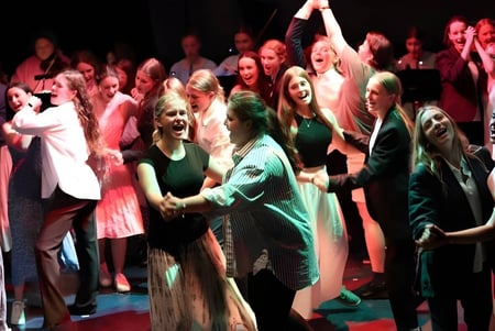 Eine Gruppe von Schülerinnen und Schülern der École Salish Secondary School feiert gemeinsam auf der Bühne.