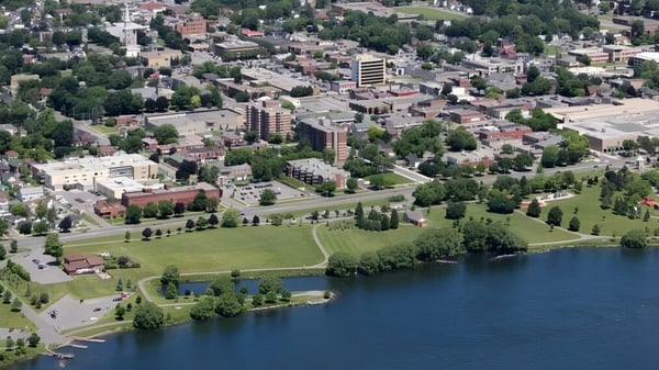 Luftaufnahme einer Stadtlandschaft mit Seen und Gebäuden in der Umgebung der École secondaire publique L'Héritage.