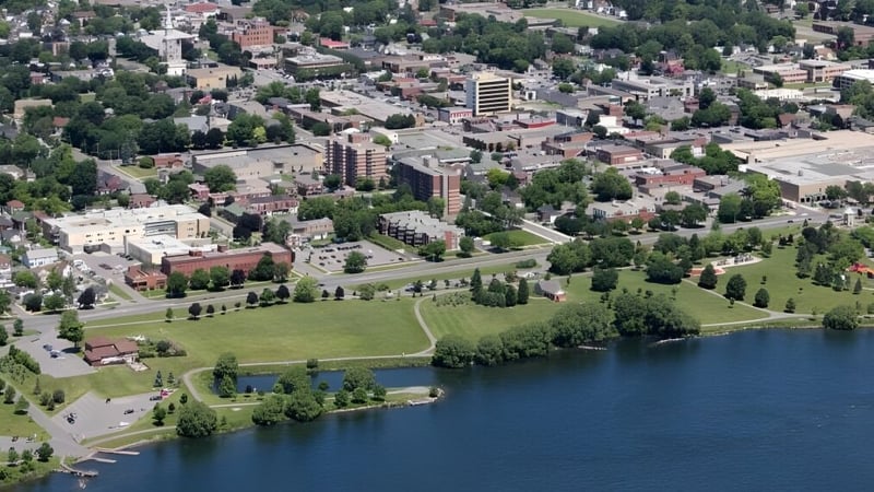 Luftaufnahme einer Stadtlandschaft mit Seen und Gebäuden in der Umgebung der École secondaire publique L'Héritage.