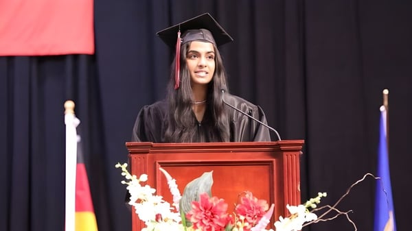 Eine Schülerin der Eden Prairie Schools hält eine Rede am Rednerpult während der Abschlussfeier auf der Bühne.
