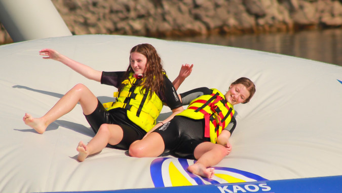 Zwei Personen in Schwimmwesten sitzen auf einem Schlauchboot in der Natur auf dem Gelände des Edmund Rice College.