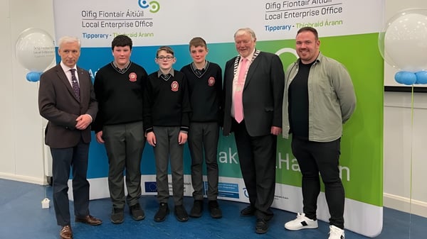 Schüler der Edmund Rice Secondary School stehen vor einer Kulisse mit dem Schriftzug Clonmel Enterprise Office.
