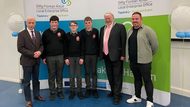 Schüler der Edmund Rice Secondary School stehen vor einer Kulisse mit dem Schriftzug Clonmel Enterprise Office.