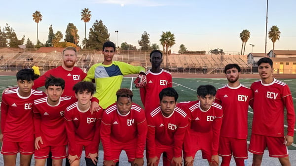 Eine Gruppe junger Fußballspieler in roten Trikots posiert gemeinsam auf dem Spielfeld der El Cajon Valley High School.